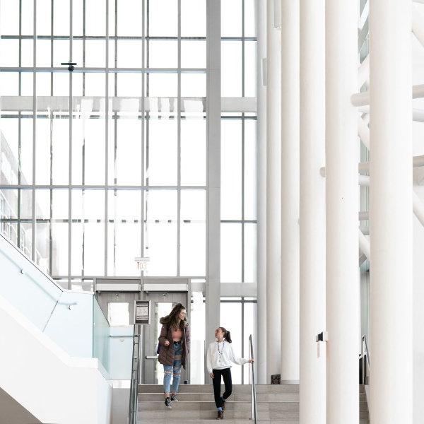 two students walk down the steps inside the Mary Idema Pew Library